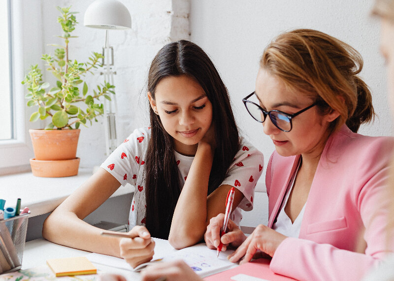 Une jeune fille révise ses cours avec une dame plus âgée qu'elle.